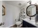 Chic half bathroom with an accent mirror, dark vanity, and modern fixtures providing a stylish and functional powder room at 640 Saddle Ridge Trce, Roswell, GA 30076