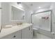 A bright bathroom with a white vanity, sink, toilet, and bathtub with glass shower doors at 640 Saddle Ridge Trce, Roswell, GA 30076