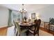 Dining room with hardwood floors, wooden table and chairs, large window with curtains, and elegant lighting at 640 Saddle Ridge Trce, Roswell, GA 30076