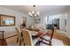 Dining area featuring a wooden table with seating for six, chandelier, hardwood floors, and neutral wall color at 640 Saddle Ridge Trce, Roswell, GA 30076