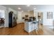 Open kitchen featuring white cabinets, stainless steel refrigerator and appliances, island, and hardwood floors at 640 Saddle Ridge Trce, Roswell, GA 30076