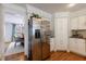 Bright kitchen with a stainless steel refrigerator, white cabinets, and hardwood floors at 640 Saddle Ridge Trce, Roswell, GA 30076