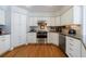 Updated kitchen featuring white cabinetry, granite countertops, hardwood floors and stainless steel appliances at 640 Saddle Ridge Trce, Roswell, GA 30076