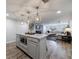 Open-concept kitchen with a kitchen island, hardwood floors, and modern lighting fixtures offering a modern entertaining space at 640 Saddle Ridge Trce, Roswell, GA 30076