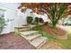 Stone steps lead to a garden with mature trees and landscaping at 640 Saddle Ridge Trce, Roswell, GA 30076