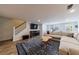 Cozy living room featuring a fireplace, staircase, and a large sectional, creating a welcoming and comfortable atmosphere at 640 Saddle Ridge Trce, Roswell, GA 30076