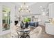 Stylish dining area featuring a glass table, modern chandelier, and views into the kitchen and living room at 1019 Cooks Farm Way, Woodstock, GA 30189