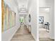 Inviting hallway with modern lighting, neutral walls, and elegant wood-look floors leading into a well-lit room at 1019 Cooks Farm Way, Woodstock, GA 30189