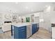 Open-concept kitchen with blue island, white cabinets, stainless steel appliances, and hardwood floors at 1019 Cooks Farm Way, Woodstock, GA 30189