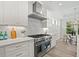 Gourmet kitchen with stainless steel appliances, quartz countertops, tile backsplash, and adjacent dining room at 1019 Cooks Farm Way, Woodstock, GA 30189