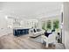 Bright, open living room with modern furnishings, large windows, and a view into the kitchen area at 1019 Cooks Farm Way, Woodstock, GA 30189