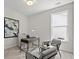 Cozy office space with neutral walls, desk, and two chairs, illuminated by natural light from a large window at 1019 Cooks Farm Way, Woodstock, GA 30189
