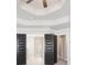 Elegant bedroom featuring trey ceilings and dark paneled doors to the ensuite bath at 3002 Blue Stone Ct, Dacula, GA 30019