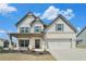 Charming two-story home with white brick, gray siding, covered porch, and a two-car garage at 3002 Blue Stone Ct, Dacula, GA 30019