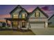 Charming two-story home with white brick, gray siding, covered porch, and a two-car garage at dusk at 3002 Blue Stone Ct, Dacula, GA 30019