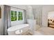 A luxury bathroom with a soaking tub, glass shower, and a large window at 369 Pinecrest Ne Rd, Atlanta, GA 30342