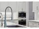 Modern kitchen with white cabinets, stainless steel appliances, and herringbone backsplash at 369 Pinecrest Ne Rd, Atlanta, GA 30342