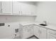 Well-lit laundry room featuring white cabinets, quartz countertops, and a sink at 369 Pinecrest Ne Rd, Atlanta, GA 30342