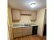 Small kitchenette featuring wood cabinets, light countertop and laminate flooring at 5098 Meadows Rd, Powder Springs, GA 30127