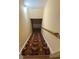View of the carpeted stairwell with wood handrail leading to the upper level at 5098 Meadows Rd, Powder Springs, GA 30127