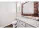 Charming half-bathroom with granite counters, wood trimmed mirror, and decorative window shutters at 815 Paden St, Woodstock, GA 30188