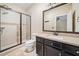 Bathroom with glass enclosed shower, dark vanity, and view into the next room at 815 Paden St, Woodstock, GA 30188