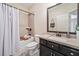 Stylish bathroom featuring a bathtub, shower, black vanity with granite counters and updated fixtures at 815 Paden St, Woodstock, GA 30188