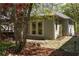 View of backyard studio with stone patio and a mature tree adding shade and character to the setting at 136 Flora Ne Ave, Atlanta, GA 30307