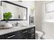 Stylish bathroom with marble countertop, black vanity, large mirror, and subway tile shower at 136 Flora Ne Ave, Atlanta, GA 30307