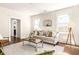 Cozy living room with hardwood floors, neutral sofa, decorative pillows, and large windows at 136 Flora Ne Ave, Atlanta, GA 30307