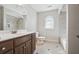 Well-lit bathroom featuring a single vanity and arched window accenting the tiled shower and floors at 1754 Water Springs Way, Dacula, GA 30019