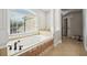 Bathroom featuring large bathtub under a window with decorative tile and pillars at 1754 Water Springs Way, Dacula, GA 30019
