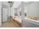 Bathroom featuring large bathtub, tile surround, and large windows at 1754 Water Springs Way, Dacula, GA 30019
