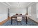 Elegant dining room featuring hardwood floors, wainscoting, a modern chandelier, and natural light at 1754 Water Springs Way, Dacula, GA 30019