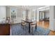 Elegant dining room featuring hardwood floors, wainscoting, a modern chandelier, and abundant natural light at 1754 Water Springs Way, Dacula, GA 30019