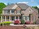 Charming two-story brick home with a stone facade, covered porch, and beautifully landscaped front yard at 1754 Water Springs Way, Dacula, GA 30019