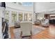 Open living room with a fireplace, hardwood floors, large windows, and a view of the kitchen at 1754 Water Springs Way, Dacula, GA 30019