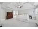 Spacious main bedroom featuring tray ceiling, ceiling fan, and decorative wood cabinet at 1754 Water Springs Way, Dacula, GA 30019