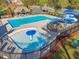 Aerial view of a refreshing swimming pool with slide and a splash pad, all within a fenced area at 1754 Water Springs Way, Dacula, GA 30019
