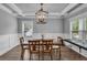 Dining room with a wood table and chairs, decorative lighting, coffered ceiling, wainscoting, and large windows at 505 Bryson Lake Cir, Douglasville, GA 30134