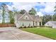 Side view of the home featuring a long driveway leading to the garage, with green lawn and a partially wooded backyard at 505 Bryson Lake Cir, Douglasville, GA 30134