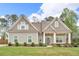 Charming home with green lawn, stone accents, neutral siding, dormer windows, covered porch with decorative pillars at 505 Bryson Lake Cir, Douglasville, GA 30134