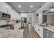 Bright kitchen features white cabinetry, granite counters, and modern stainless steel appliances, with recessed lights and pendant lights at 505 Bryson Lake Cir, Douglasville, GA 30134