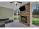 Covered outdoor living space with a stone fireplace and TV at 505 Bryson Lake Cir, Douglasville, GA 30134