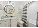 Well-lit bathroom showcasing a vanity with marble top, modern fixtures, and shower with stylish curtain at 6820 Glenridge Dr # C, Sandy Springs, GA 30328