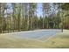 Well-maintained tennis court surrounded by tall trees, offering a serene and private recreational space at 6820 Glenridge Dr # C, Sandy Springs, GA 30328