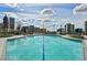 Rooftop pool surrounded by city views and lounge seating under a bright, cloudy sky at 860 Peachtree Ne St # 2716, Atlanta, GA 30308