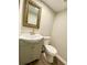 An updated half bath features laminate floors, a decorative mirror and a single vanity at 927 Pine Oak Trl, Austell, GA 30168