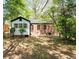 View of the home's exterior, showcasing the brick and white siding, with a spacious yard at 1700 John Calvin Ave, Atlanta, GA 30337