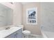 Well-lit bathroom with marble tiling, a new vanity, and modern fixtures at 1700 John Calvin Ave, Atlanta, GA 30337